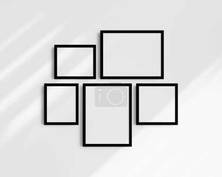 Foto de Conjunto de maquetas de pared Gallery, 5 marcos negros. Maqueta de marco limpia, moderna y minimalista. Dos marcos horizontales, dos marcos verticales, y un marco cuadrado, 12x16 (3: 4), 16x12 (4: 3), 8x10 (4: 5), 10x8 (5: 4), 10x10 (1: 1) pulgadas, en una pared blanca con sombras. - Imagen libre de derechos