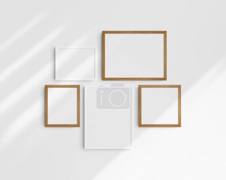 Foto de Conjunto de maquetas de pared Gallery, 5 marcos de madera blanca y cerezo. Una maqueta moderna. Dos marcos horizontales, dos marcos verticales, y un marco cuadrado, 12x16 (3: 4), 16x12 (4: 3), 8x10 (4: 5), 10x8 (5: 4), 10x10 (1: 1) pulgadas, en una pared blanca con sombras. - Imagen libre de derechos