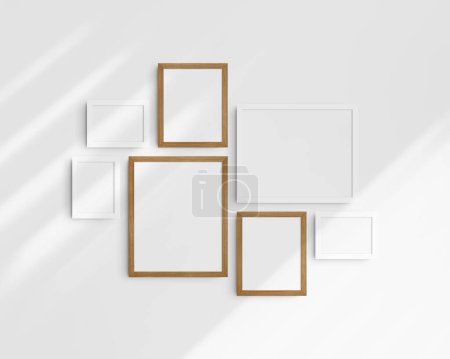 Foto de Conjunto de maquetas de pared Gallery, 7 marcos de madera blanca y cerezo. Maqueta de marco limpia, moderna y minimalista. Tres marcos horizontales, y cuatro verticales, 5x7 (5: 7), 7x5 (7: 5), 8x10 (4: 5), 12x15 (4: 5), 15x12 (5: 4) pulgadas, en una pared blanca con sombras. - Imagen libre de derechos