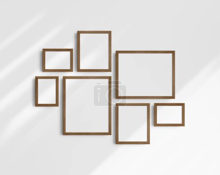 Photo for Gallery wall mockup set, 7 brown walnut wood frames. Clean, modern, and minimalist frame mockup. Three horizontal frames, and four vertical frames, 5x7 (5:7), 7x5 (7:5), 8x10 (4:5), 12x15 (4:5), 15x12 (5:4) inches, on a white wall with shadows. - Royalty Free Image