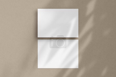 Two white horizontal paper sheets mockup, A4/A5/A6 flyer mockup, paper, letter, invitation card, on a beige background with a botanical shadow overlay.
