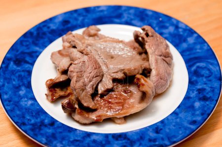 Téléchargez les photos : Porc frit dans une assiette blanche sur la table. - en image libre de droit