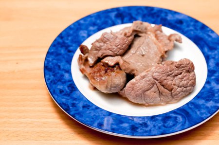Téléchargez les photos : Porc frit dans une assiette blanche sur la table. - en image libre de droit
