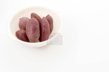 Téléchargez les photos : Igname violette en passoire plastique blanche - en image libre de droit