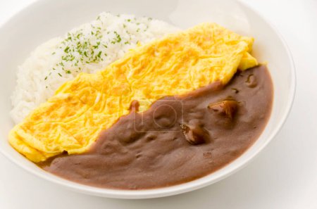 Japanischer Curry-Reis mit Omelett in einem weißen Gericht auf weißem Hintergrund.