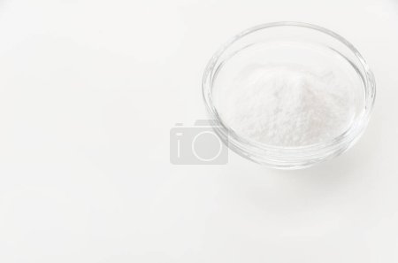 Tazón de vidrio de bicarbonato de sodio aislado sobre fondo blanco 