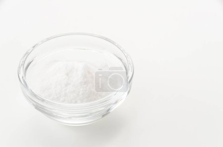 Tazón de vidrio de bicarbonato de sodio aislado sobre fondo blanco 