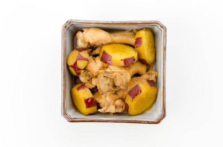 des patates douces mijotées et des ailes de poulet dans un bol carré profond
