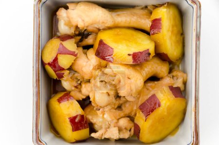 köchelten Süßkartoffeln und Chicken Wings in einer tiefen quadratischen Schüssel