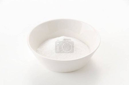 White bowl of baking soda on white background