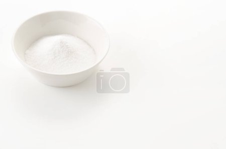 Cuenco blanco de bicarbonato de sodio sobre fondo blanco