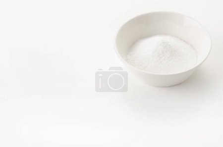 Cuenco blanco de bicarbonato de sodio sobre fondo blanco