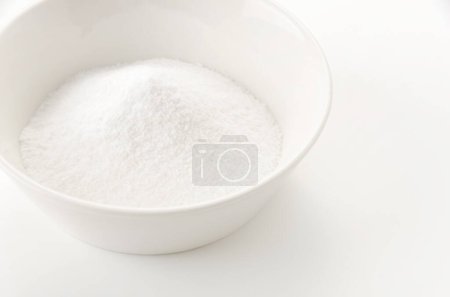 Bol blanc de bicarbonate de soude sur fond blanc