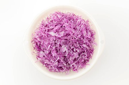 Colander and shredded red cabbage on white background 