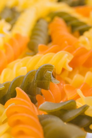 Three-colored Fusilli pasta close-up. Macro shot of  the uncooked colorful pasta.