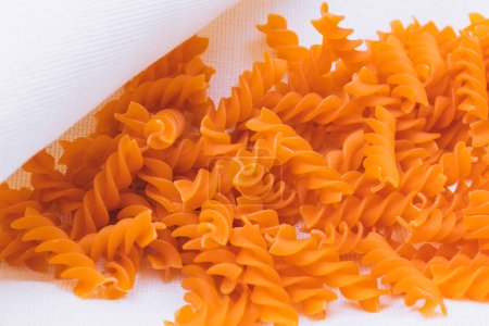 Téléchargez les photos : Pâtes Fusilli orange sur la nappe. - en image libre de droit