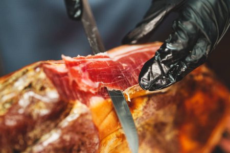 Photo for Chef cutting dry-cured spanish ham Jamon. - Royalty Free Image
