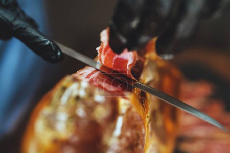 Photo for Chef cutting dry-cured spanish ham Jamon. - Royalty Free Image