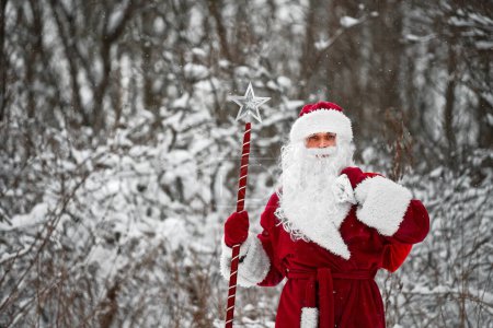 Foto de Papá Noel con bastón mágico y saco de regalos de Navidad. - Imagen libre de derechos