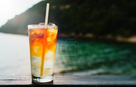 Glass of Mai Tai cocktail in front of the sea background.