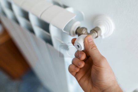 Téléchargez les photos : Thermostat à réglage manuel masculin pour allumer le radiateur à la maison
. - en image libre de droit