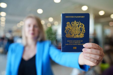 Foto de Mujer que muestra pasaporte de Reino Unido. - Imagen libre de derechos