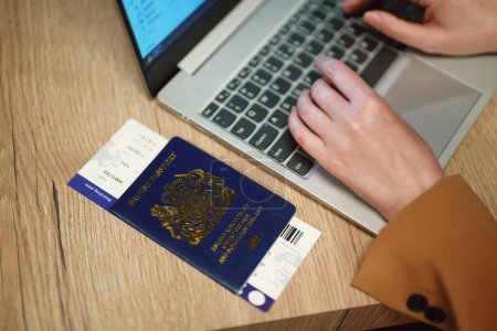 Foto de Mujer con pasaporte del Reino Unido está esperando su vuelo. - Imagen libre de derechos