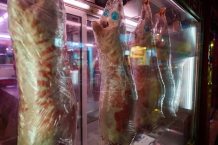 Téléchargez les photos : Des carcasses de porc égorgées pendent dans une boucherie. - en image libre de droit