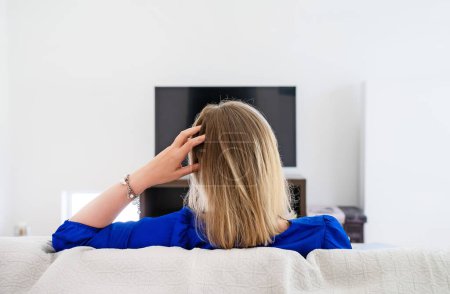 Téléchargez les photos : Une femme attend qu'un film se charge à la télé. Connexion Internet lente. - en image libre de droit