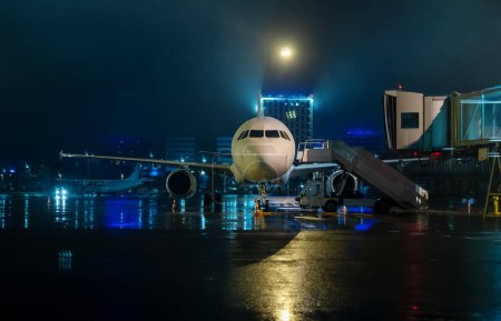 Photo for Airplane with a ramp at the airport at night. - Royalty Free Image
