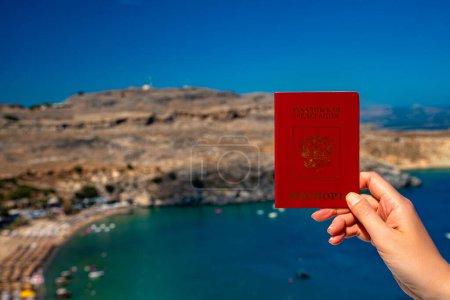 Téléchargez les photos : Femme détenant un passeport russe dans le contexte d'un pays tropical. - en image libre de droit