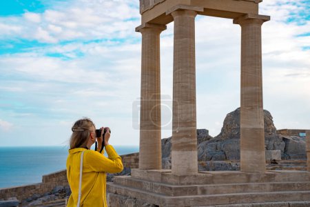 Photo for A woman tourist with a camera in the Acropolis on an excursion. - Royalty Free Image