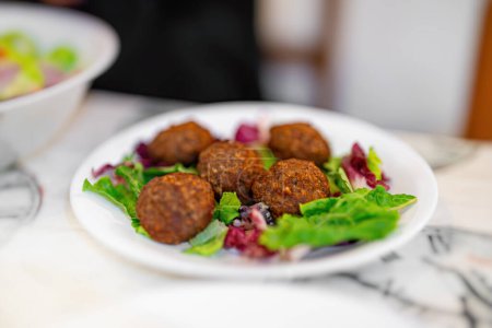 Greek meatballs with lettuce on a plate.