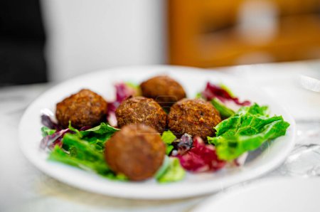 Greek meatballs with lettuce on a plate.