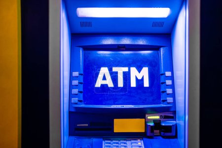 Geldautomat nachts beleuchtet.