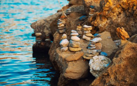 Muchas piedras ZEN en la playa del atardecer.