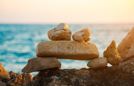 Muchas piedras ZEN en la playa del atardecer.