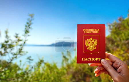 Man holding Russian passport against the backdrop of a tropical country.