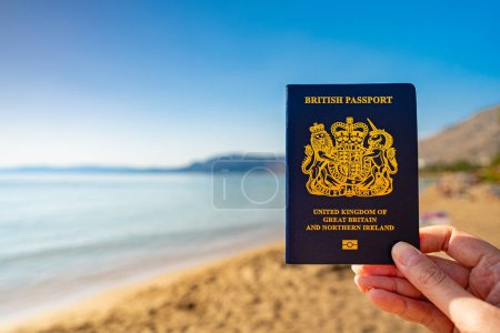 Man holding UK passport against the backdrop of a tropical country.