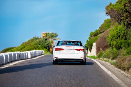 Photo for White cabrio car is driving along the road. Back view. - Royalty Free Image