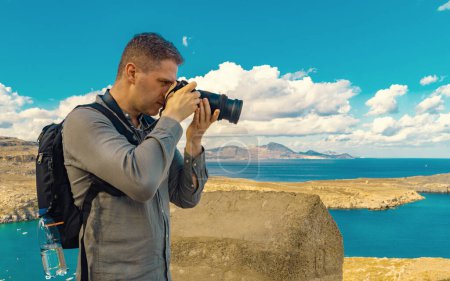 El hombre toma una fotografía de la bahía de Lindos.