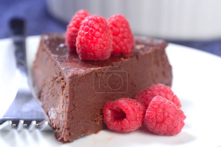 Téléchargez les photos : Gâteau au chocolat sans farine servi avec des framboises fraîches - en image libre de droit