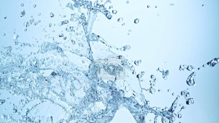 Photo for Water splash isolated on soft blue background. Freeze motion of exploding water up in the air. - Royalty Free Image