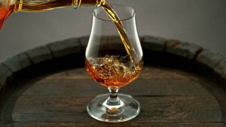 Foto de Pouring cognac into the glass, macro shot. Freeze motion in detail. - Imagen libre de derechos