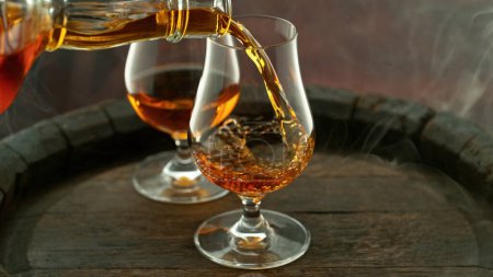 Foto de Pouring cognac into the glass, macro shot. Freeze motion in detail. - Imagen libre de derechos