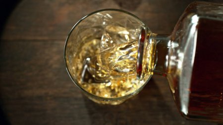 Téléchargez les photos : Pouring whisky into the glass, macro shot. Freeze motion in detail. - en image libre de droit