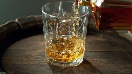 Téléchargez les photos : Pouring whisky into the glass, macro shot. Freeze motion in detail. - en image libre de droit