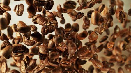 Foto de Coffee beans flying in the air in freeze motion. Abstract coffee background with roasted beans. - Imagen libre de derechos