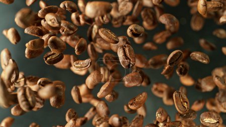 Foto de Coffee beans flying in the air in freeze motion. Abstract coffee background with roasted beans. - Imagen libre de derechos