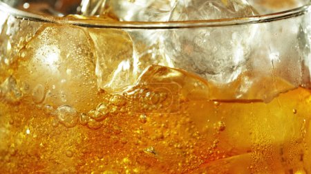 Foto de Detail of cider with ice cubes in glass. Extreme closeup, fresh beverages background. - Imagen libre de derechos